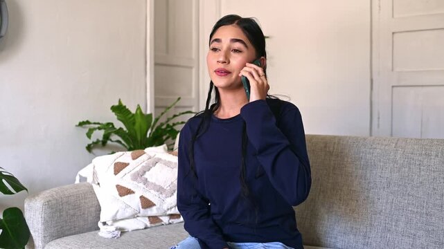 Young woman having an emotional phone conversation at home