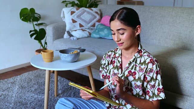 Teenager drawing on a tablet in living room