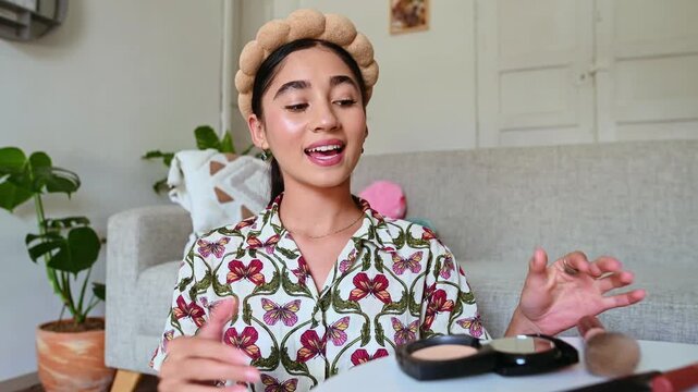 Young beauty blogger applying blush during a makeup tutorial