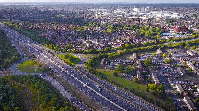 Drone photo of M4 motorway cutting through Slough, UK. Includes traffic, housing, farmland, and waterway&mdash;ideal for real estate, infrastructure, commuting, or transportation themes