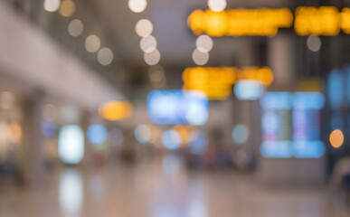 Fototapeta premium A blurry view of an airport interior showcasing illuminated signs and indirect lighting, conveying a sense of motion and travel ambiance.