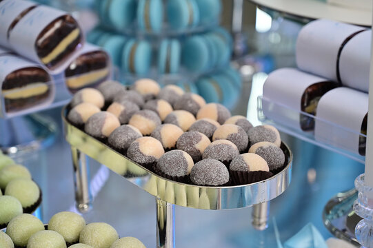 gourmet party candy buffet at elegant celebration, delicious confectionery assortment on luxury stand, wedding sweet table decoration close up, blue macarons and chocolate bonbons