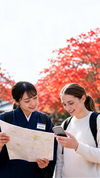 紅葉の観光地で地図とスマートフォンを確認する日本人ガイドと外国人女性