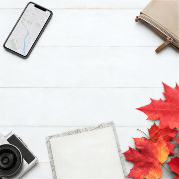 スマートフォンの地図とカメラ、紅葉を並べた秋旅行のフラットレイ