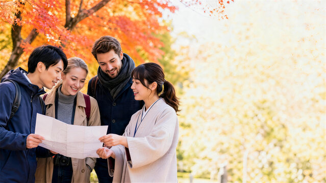 紅葉の観光地で地図を囲む日本人ガイドと外国人旅行者