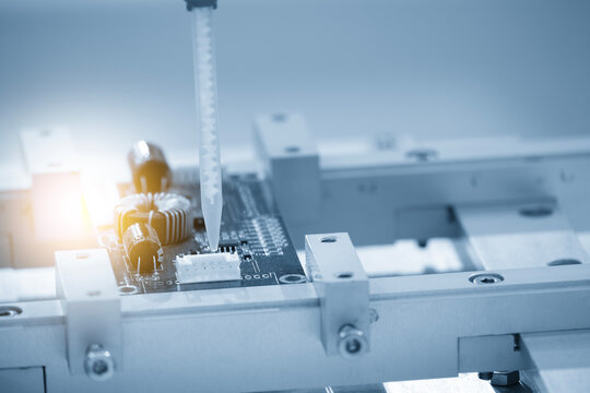 High-precision industrial soldering robot working automatically on an electronics circuit board.