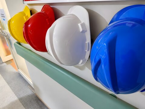 Colorful safety helmets hanging on the wall