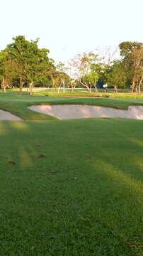Tropical Golf Course Landscape with Sand Trap and Green Fairway
