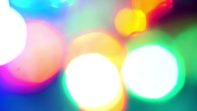 Blurred neon circles shining in vivid bokeh, perfect for backgrounds, textures, or futuristic design elements in graphic designs and websites.