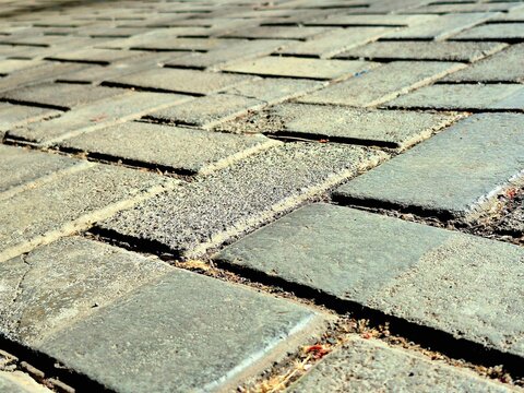Textured concrete brick pavers walkway background with fine cracks