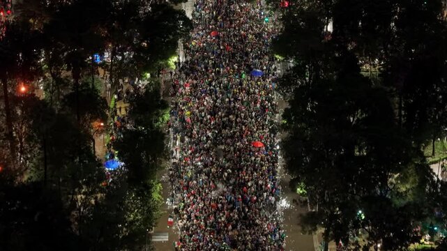 A panoramic bird's-eye view of the Reforma promenade at night, filled with people celebrating the Mexican soccer team's victory
