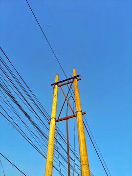 Concrete utility poles with electrical wires standing against clear blue sky for power distribution infrastructure