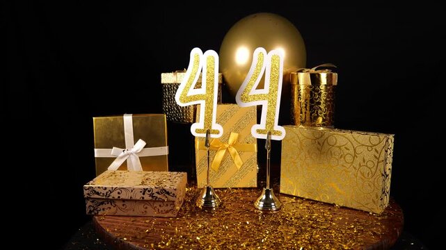 Gold Number 44 with Gold Glitter Confetti Sparkles with Gifts and Balloons for Party Forty Four