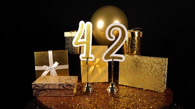 Gold Number 42 with Gold Glitter Confetti Sparkles with Gifts and Balloons for Party Forty Two