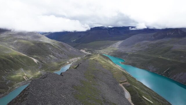 Drone view of Baimalincuo and Zhegong three lakes in Mount Kula Kangri in sunny cloudy day, well-built hiking trail circling its shore. 4k real time footage travel concept b roll shot.