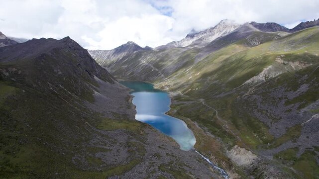 Drone view of Baimalincuo and Zhegong three lakes in Mount Kula Kangri in sunny cloudy day, well-built hiking trail circling its shore. 4k real time footage travel concept b roll shot.