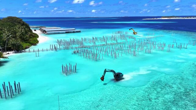 Excavators building foundations at an ocean construction site