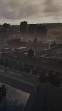 The scene shows a city skyline with various buildings shrouded in fog. The view captures a river along the edge and trees in the foreground. The atmosphere appears cloudy and muted.