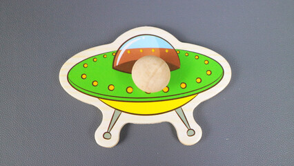 Colorful Wooden UFO Puzzle Toy on Gray Background © Adipra