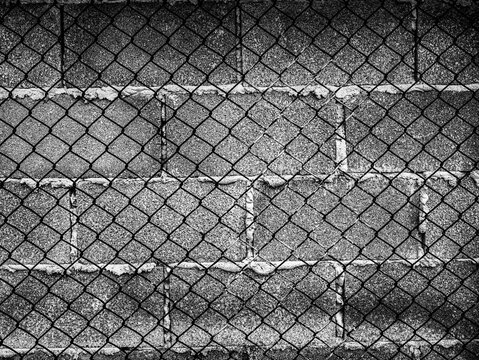 Black and White Chain Link Wire Fence Over Old Weathered Concrete Wall, Urban Grunge Abstract