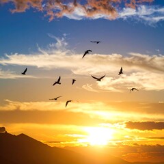 Fototapeta premium Birds Flying in Sunset Sky Over Mountains