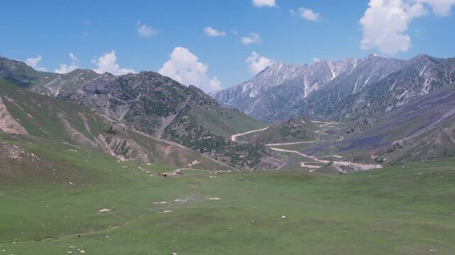 Dasht e Laila meadows stretch toward Badgoi Pass with winding mountain roads near Kalam, Pakistan