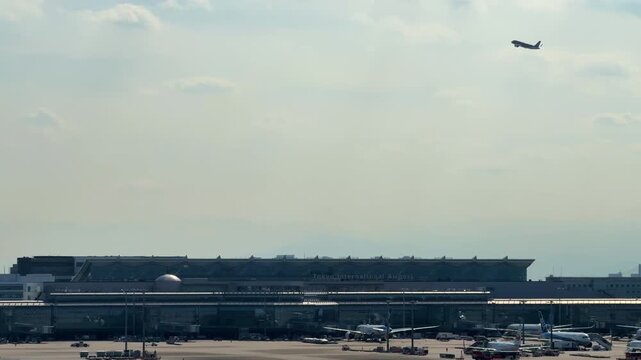 羽田空港 第1ターミナル 展望デッキから望む第3ターミナル周辺の風景と上空を通過する航空機