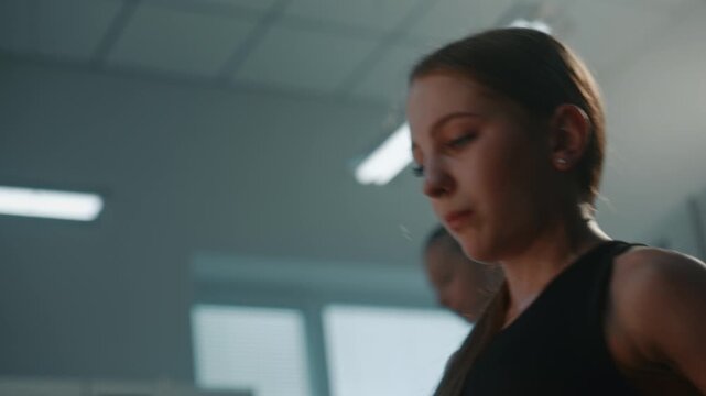Dedicated Female Athlete Performing Core Sit Ups, Abdominal Crunches. Teenage Maintains Strong Form and High Focus During Workout Routine. Authentic, Motivating Atmosphere of Local Gymnastics School.
