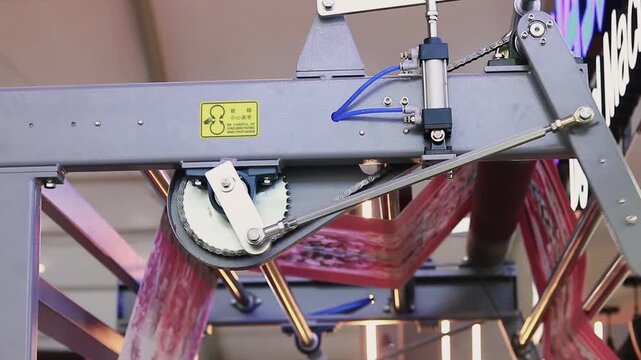 Industrial fabric rolling machine winding large roll of white textile material in factory, close up shot