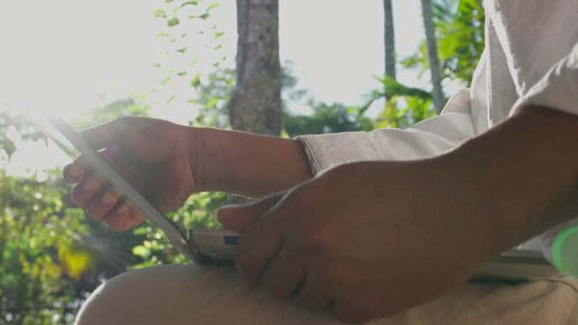 Man opening laptop to begin focused remote work in a peaceful natural environment, illustrating digital nomad lifestyle, work-life balance, outdoor productivity, and intentional work habits