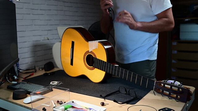 Luthier carefully repairing a classical guitar in his workshop