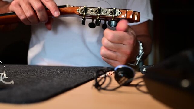 Musician changing strings on a classical guitar