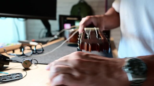 Male luthier hands changing classical guitar strings