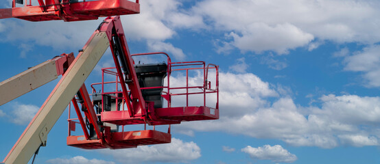 Articulated boom lift. Aerial platform lift. Telescopic boom lift against blue sky. Mobile construction crane for rent and sale. Maintenance and repair hydraulic boom lift service. Crane dealership. © Fahroni