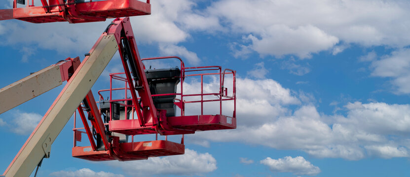 Articulated boom lift. Aerial platform lift. Telescopic boom lift against blue sky. Mobile construction crane for rent and sale. Maintenance and repair hydraulic boom lift service. Crane dealership.