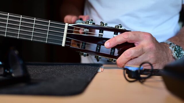 Musician man replacing strings on a classic guitar