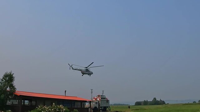The Mi-8 helicopter makes an approach over the airfield. The aircraft is at low altitude against the background of the open sky and flight infrastructure.
