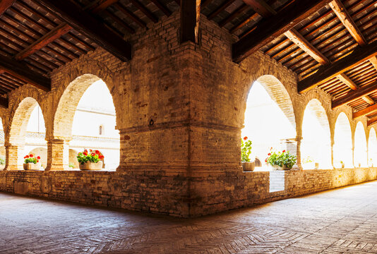 Arcaded colonnade in the cloister of the Cistercian Abbey of Fiastra in Marche, Italy, featuring medieval stone architecture and monastic design