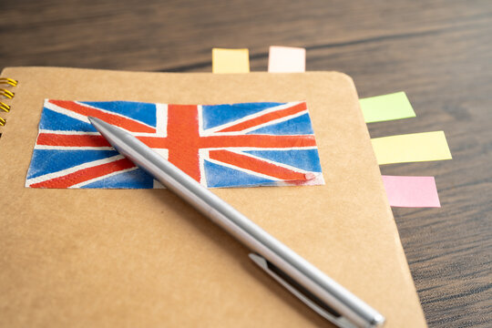UK flag with pen on english language book.