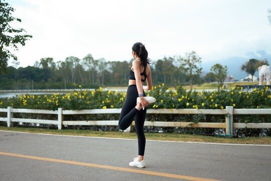 Woman stretching leg outdoors preparing for a run