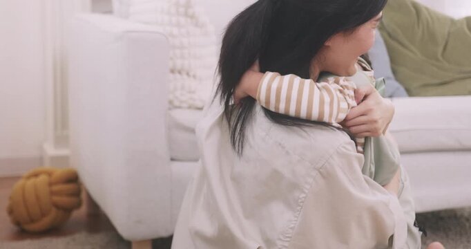 Happy Asian little girl with backpack running to hug and kiss her mother at home, back to school and happy family concept.
