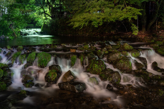 京都・貴船の夜を流れる貴船川。京都・貴船の森を静かに流れる貴船川。ライトアップされた夜の川と豊かな自然が幻想的な雰囲気を演出する夏の風景。