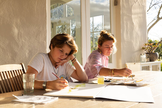 female art instructor with her student outdoors doing watercolor paintings