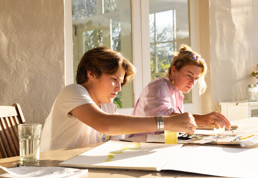 female art instructor with her student outdoors doing watercolor paintings