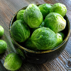 Fototapeta premium Fresh Brussels Sprouts in Wooden Bowl