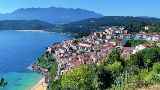 Panoramic aerial view of coastal village lastres with red roofs by turquoise ocean in asturias spain
