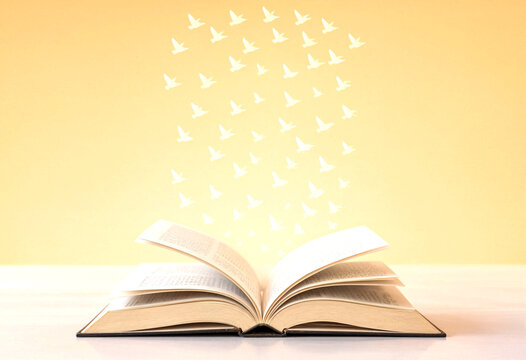 Open book with glowing pages and white birds flying out symbolizing imagination and freedom of ideas