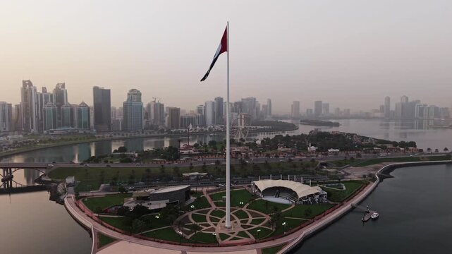 Cinematic Aerial Drone shot of Sharjah at early morning golden hour, UAE Flag, Sharjah Skyline and Sharjah Corniche in the background