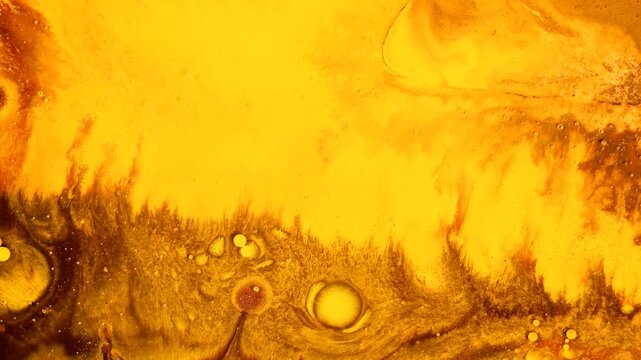 Hypnotic fluid art footage showing beautiful yellow and dark organic liquid marble textures blending, creating mesmerizing moving bubbles and cell structures.