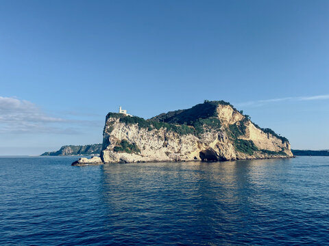 Cape Miseno Lighthouse, Gulf of Naples, Italy in sunny summer. Cape Miseno Lighthouse on high rock in deep blue sea, Gulf of Naples, Italy in sunny summer day